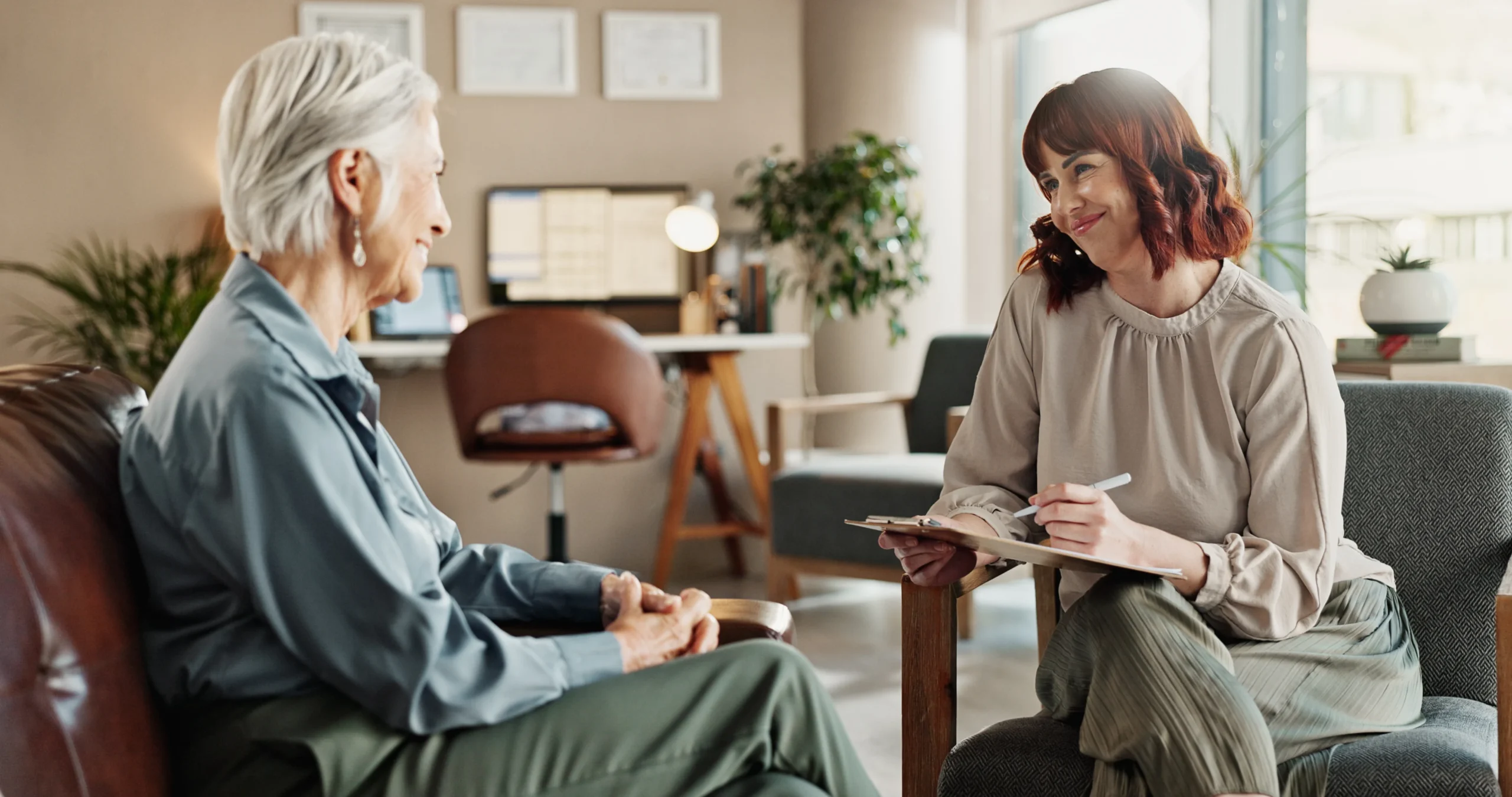 psychologist talking senior woman with notes smile from mental health assessment consultation writing support care with counseling psychology evaluation with advice office